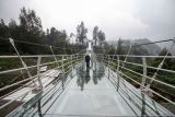 Pekerja berjalan di atas jembatan gantung kaca di Seruni Point Kawasan Strategis Pariwisata Nasional (KSPN) Bromo-Tengger-Semeru, Probolinggo, Jawa Timur, Selasa (29/11/2022). Kementerian PUPR membangun jembatan sepanjang 120 meter yang dapat menampung 100 orang tersebut untuk menunjang perkembangan pariwisata dan perekonomian masyarakat di kawasan Bromo. ANTARA FOTO/Umarul Faruq/nym.