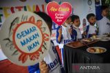 Anak - anak memakan ikan saat festival ikan milenial di Gedung Sate, Bandung, Jawa Barat, Jumat (2/12/2022). Festival tersebut digelar dalam rangka kampanye gemar makan ikan sekaligus upaya pencegahan stunting pada anak. ANTARA FOTO/Raisan Al Farisi/agr