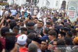 Bakal Calon Presiden dari Partai NasDem, Anies Baswedan  (tengah) berada dalam kerumunan warga seusai melaksanakan shalat Jumat di Masjid Raya Baiturrahman, Banda Aceh, Jumat (2/12/2022). Kunjungan Anies Baswedan bersama sejumlah pengurus Partai NasDem di Aceh itu dalam rangka  menjalin silaturrahmi dengan Wali Nanggroe Aceh, Malik Mahmud, para ulama, tokoh adat serta dengan  pendukungnya. ANTARA FOTO/Ampelsa.