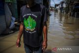 Warga melintasi banjir luapan Sungai Citarum di Kampung Bojongasih, Dayeuhkolot, Kabupaten Bandung, Jawa Barat, Sabtu (3/12/2022). Hujan dengan intensitas tinggi pada Jumat (2/12/2022) membuat ratusan rumah di Kecamatan Baleendah dan Dayeuhkolot terendam banjir luapan Sungai Citarum setinggi 50 sentimeter hingga satu meter. ANTARA FOTO/Raisan Al Farisi/agr