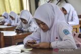 Siswa mengerjakan soal ujian menggunakan telepon pintar saat mengikuti Penilaian Akhir Semester (PAS) di SMK Negeri 1 Ciamis, Kabupaten Ciamis, Jawa Barat, Senin (5/12/2022). Sebanyak 1.695 siswa mengikuti penilaian akhir semester berbasis 