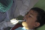 Dokter gigi dan petugas kesehatan memeriksa gigi siswa SD yang mengikuti 