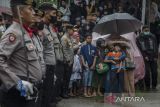 Istri bersama anak almarhum Aiptu Anumerta Sofyan menangis saat upacara serah terima untuk pemakaman secara kedinasan di rumah duka kawasan Cibogo, Bandung, Jawa Barat, Rabu (7/12/2022). Aiptu Anumerta Sofyan merupakan korban meninggal dunia dalam peristiwa ledakan bom bunuh diri di Markas Polsek Astana Anyar. ANTARA FOTO/Novrian Arbi/agr