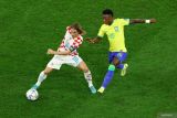 Pesepak bola Kroasia Luka Modric (kiri) berebut bola dengan pesepak bola Btazill Vinicius Junior dalm laga babak perempat final Piala Dunia 2022, di Stadion Education City Stadium, Doha, Qatar, Jumat (9/12/20220. Babak pertama usai Brazil vs Kroasia masih tanpa gol. ANTARA FOTO/Reuters-Lee Smith/hp.