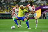 Pesepak bola Brazil Richarlison (tengah) berebut bola dengan pesepak bola Kroasia Josko Gvardiol dalam laga babak perempat final Piala Dunia 2022, di Stadion Education City Stadium, Doha, Qatar, Jumat (9/12/2022). Babak pertama usai Brazil vs Kroasia masih tanpa gol. ANTARA FOTO/Reuters-Annegret Hilse/hp.