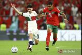 Pemain timnas Portugal Vitinha (kiri) berebut bola dengan pemain timnas Maroko Walid Cheddira pada babak perempat final Piala Dunia Qatar 2022 di Stadion Al Thumama, Doha, Qatar, Sabtu (10/12/2022). Portugal tersingkir dari Piala Dunia 2022 usai keok oleh Maroko 0-1. ANTARA FOTO/REUTERS/Carl Recine/wsj.