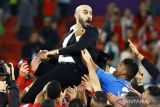 Pelatih timnas Maroko Walid Regragui (tengah) berselebrasi dengan anak asuhnya usai menang melawan Portugal pada babak perempat final Piala Dunia Qatar 2022 di Stadion Al Thumama, Doha, Qatar, Sabtu (10/12/2022). Portugal tersingkir dari Piala Dunia 2022 usai keok oleh Maroko 0-1. ANTARA FOTO/REUTERS/Suhaib Salem/wsj.