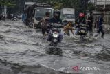 Pengendara melintasi genangan banjir di kawasan Kopo, Bandung, Jawa Barat, Senin (12/12/2022). Kawasan tersebut kerap dilanda banjir akibat drainase yang buruk saat intensitas curah hujan yang tinggi yang mengganggu akses lalu lintas dan merendam sejumlah pemukiman warga. ANTARA FOTO/Novrian Arbi/agr