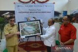 Kepala Biro Perum LKBN ANTARA provinsi Aceh, Azhari (kanan) memberikan cenderamata foto Museum Tsunami kepada Pj Wali Kota Banda Aceh Bakri Siddiq saat pembukaan pameran foto di Banda Aceh, Aceh, Selasa (13/12/2022). Pameran foto bertema, Indonesia Menyintas Bencana menampilkan berbagai peristiwa bencana gempa dan tsunami, bencana gunung meletus dan bencana banjir di Indonesia itu dalam memeriahkan HUT ke 85 Perum LKBN ANTARA. ANTARA FOTO/Ampelsa.