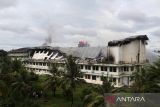 Petugas pemadam kebakaran memadamkan sisa api yang membakar gedung lantai empat Universitas Abulyamatama di Desa Keude, Kecamatan Kuta Baro, Kabupaten Aceh Besar, Aceh, Rabu (14/12/2022). Kebakaran yang mengakibatkan gedung lantai empat Universitas Abulyatama roboh tersebut , masih dalam dalam penyelidikan aparat terkait  dan Badan Penanggulangan Bencana Daerah (BPBA)mengerahkan sebanyak 11 unit mobil pemadam untuk memadamkan api. ANTARA FOTO/Ampelsa.