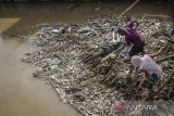 Warga membersihkan tumpukan sampah pada aliran Sungai Cikapundung kawasan Citereup, Dayeuhkolot, Kabupaten Bandung, Jawa Barat, Sabtu (17/12/2022). Menurut warga tumpukan sampah kiriman yang terbawa arus aliran Sungai Cikapundung menuju Sungai Citarum itu terus meningkat disebabkan volume air yang naik saat intensitas curah hujan yang tinggi. ANTARA FOTO/Novrian Arbi/agr