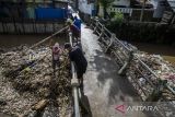 Warga membersihkan tumpukan sampah pada aliran Sungai Cikapundung kawasan Citereup, Dayeuhkolot, Kabupaten Bandung, Jawa Barat, Sabtu (17/12/2022). Menurut warga tumpukan sampah kiriman yang terbawa arus aliran Sungai Cikapundung menuju Sungai Citarum itu terus meningkat disebabkan volume air yang naik saat intensitas curah hujan yang tinggi. ANTARA FOTO/Novrian Arbi/agr