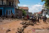 Warga membersihkan puing akibat banjir bandang di Sawahdadap, Cimanggung, Kabupaten Sumedang, Jawa Barat, Minggu (18/12/2022). Terjangan banjir bandang akibat intensitas hujan yang tinggi pada Sabtu (17/12/2022) petang tersebut mengakibatkan sejumlah rumah rusak dan ratusan warga mengungsi serta dua orang meninggal dunia. ANTARA FOTO/Ahmad Fauzan/rai/agr
