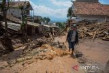 Warga melintasi puing akibat banjir bandang di Sawahdadap, Cimanggung, Kabupaten Sumedang, Jawa Barat, Minggu (18/12/2022). Terjangan banjir bandang akibat intensitas hujan yang tinggi pada Sabtu (17/12/2022) petang tersebut mengakibatkan sejumlah rumah rusak dan ratusan warga mengungsi serta dua orang meninggal dunia. ANTARA FOTO/Ahmad Fauzan/rai/agr
