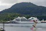 Seorang warga berada di menara menyaksikan  kapal pesiar MS Seabourn Encore berbendera Bahamas saat kedatangan di pelabuhan CT3 Badan Pengusahaan Kawasan Sabang (BPKS) provinsi Aceh, Senin (19/12/2022). Kapal pesiar MS Seabourn Encore membawa sebanyak 512 wisatawan dan 440 crew itu akan berada di Sabang selama delapan jam mengunjungi sejumlah objek wisata di pulau tersebut sebelum melanjutkan perjalanan menuju Phuket, Thailand. ANTARA FOTO/Ampelsa.