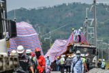 Pekerja menutupi bangkai kereta teknis yang mengalami kecelakaan menggunakan kain di Campaka Mekar, Kabupaten Bandung Barat, Jawa Barat, Senin (19/12/2022). Kadiv Humas Polri Irjen Pol Dedi Prasetyo menyatakan, kecelakaan kereta teknis pada proyek Kereta Cepat Jakarta Bandung yang terjadi pada Minggu (18/12/2022) sore tersebut mengakibatkan dua orang pekerja yang berkewarganegaan China meninggal dunia dan lima orang luka-luka. ANTARA FOTO/Raisan Al Farisi/aww.