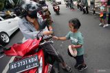 Sejumlah anak dari komunitas belajar Gubug Ayem membagikan bunga kepada ibu-ibu pengguna jalan di Kota Blitar, Jawa Timur, Kamis (22/12/2022). Selain dalam rangka memperingati Hari Ibu, aksi bagi-bagi bunga tersebut juga sebagai wujud rasa hormat dan terima kasih kepada Ibu. Antara Jatim/Irfan Anshori/Ds
