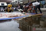 Pekerja melemparkan minuman keras (miras) saat pemusnahannya di Mapolres Jombang, Jawa Timur, Sabtu (24/12/2022). Polres Jombang memusnahkan 2.423 botol minuman keras hasil operasi selama satu bulan menjelang Natal dan tahun baru 2023, pemusnahan ini untuk menekan angka kriminalitas di wilayah Jombang. Antara Jatim/Syaiful Arif/Ds