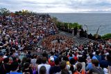 Wisatawan menyaksikan Tari Kecak di kawasan Pura Uluwatu, Badung, Bali, Rabu (28/12/2022). Tari Kecak Uluwatu yang dipentaskan dalam dua sesi setiap harinya itu menjadi salah satu atraksi wisata yang ramai dikunjungi wisatawan liburan akhir tahun di Pulau Dewata. ANTARA FOTO/Fikri Yusuf/nym.