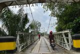 Jemabatan Penanjung merupakan jembatan gantung di Kabupaten Sekadau, Kalimantan Barat yang dibangun pada tahun 1938 oleh kolonial Belanda. Jembatan berangka baja ini  berada di Dusun Penanjung, Desa Mungguk, Kecamatan Sekadau Hilir ini memiliki panjang 90 meter dan lebar 2.5 meter melintasi Sungai Sekadau. Kondisi jembatan tua ini kini hanya boleh dilewati pejalan kaki atau sepeda motor. Meski terlihat kokoh tetapi eberapa baut bajanya kini dah banyak hilang sedangkan apan kayu juga terlihat melapuk. Foto Antara/Evy R. Syamsir