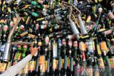 Petugas menunjukkan botol minuman keras hasil sitaan yang akan dimusnahkan di Makopolres Indramayu, Jawa Barat, Rabu (28/12/2022). Sebanyak 19.500 botol Miras dimusnahkan jelang perayaan Tahun Baru 2023. ANTARA FOTO/Dedhez Anggara/agr