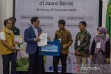 Gubernur Jawa Barat Ridwan Kamil (kedua kiri) memberikan sertifikat simbolik untuk fasilitas pengembangan kepada pelaku industri kecil menengah di Gedung Sate, Bandung, Jawa Barat, Rabu (28/12/2022). Pemerintah Provinsi Jawa Barat memberikan fasilitas berupa sertifikasi halal, sertifikasi hak kekayaan intelektual, pameran dalam negeri serta desain kemasan bagi pelaku petani milenial dan pelaku industri kecil menengah (IKM) di Jawa Barat guna meningkatkan semangat dan daya saing pasar baik dalam maupun luar negeri. ANTARA FOTO/Novrian Arbi/agr