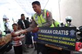 Anggota Satlantas Polres Jombang membagikan nasi kotak gratis kepada jamaah di Masjid Riyadul Jannah Kauman Utara Kabupaten Jombang, Jawa Timur, Jumat (30/12/2022). Polisi lalu lintas di Jombang setiap Jumat ini rutin membawa rengkek sedekah untuk membagikan ratusan nasi bungkus keliling Masjid dari hasil urunan anggota, dan diharapkan bisa membantu dan menanamkan rasa peduli serta lebih dekat kepada masyarakat. Antara Jatim/Syaiful Arif/Ds