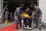 Personel TNI Angkatan Laut membantu warga dari Pulau Bawean yang turun dari KRI dr. Soeharso di Dermaga Jamrud Utara, Pelabuhan Tanjung Perak, Surabaya, Jawa Timur, Sabtu (31/12/2022). TNI Angkatan Laut memberikan dukungan transportasi laut kepada Pemkab Gresik untuk mengangkut 942 orang dari Pulau Bawean ke Surabaya menyusul adanya larangan berlayar akibat gelombang air laut tinggi dan cuaca ekstrem. Antara Jatim/Didik Suhartono