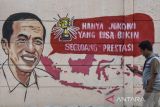 Warga melintas di dekat mural yang bertuliskan âhanya Jokowi yang bisa bikin segudang prestasiâ di Kabupaten Ciamis, Jawa Barat, Jumat  (30/12/2022). Mural tersebut merupakan wujud ekspresi dari warga sebagai bentukan dukungan dan apresiasi terhadap kinerja pemerintah di era Presiden Joko Widodo. ANTARA FOTO/Adeng Bustomi/agr
