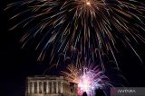 Kembang api menyemarakkan suasana malam pergantian tahun di kuil kuno Parthenon, Bukit Acropolis, Athena, Yunani, Minggu (1/1/2023). ANTARA FOTO/REUTERS/Stelios Misinas/foc.