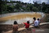 Anak - anak berada di pinggiran Kolam Retensi Cisanggarung, Sindanglaya, Bandung, Jawa Barat, Senin (2/1/2023). Kolam Retensi Cisanggarung yang baru diresmikan oleh Pemerintah Kota Bandung tersebut mampu menampung air sebanyak 6.000 meter kubik dan bertujuan untuk mencegah banjir di Kawasan Arcamanik serta Cingised Kota Bandung. ANTARA FOTO/Raisan Al Farisi/agr