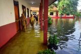 Guru mengecek kondisi sekolah yang terdampak banjir di SDN 3 Jati, Kudus, Jawa Tengah, Senin (2/1/2023). Sebanyak empat Sekolah Dasar Negeri (SD N) di kecamatan tersebut terdampak banjir sehingga aktivitas belajar mengajar diliburkan atau belajar di rumah. ANTARA FOTO/Yusuf Nugroho/foc.