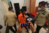 Dua orang petugas menggiring tersangka berinisial REP (tengah) usai rilis ungkap kasus pengiriman pekerja migran nonprosedural di Kantor Imigrasi Kediri, Jawa Timur, Selasa (3/1/2023). Imigrasi Kediri berhasil menggagalkan 6 orang pemohon paspor bekerja di Thailand menggunakan data palsu yang dikoordinir oleh seorang tersangka berinisial REP untuk diselundupkan ke Kambojo sebagai customer service di sebuah perusahaan game online. Antara Jatim/Prasetia Fauzani/Ds