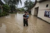 Seorang bapak menggendong anaknya saat menerobos banjir di Sobang, Pandeglang, Banten, Selasa (3/1/2023). Banjir yang terjadi karena hujan lebat dan meluapnya Sungai Cimoyan, Sungai Cikaret, dan Sungai Cilemer menyebabkan banjir di empat kecamatan di Kabupaten Pandeglang dengan ketinggian air antara 70-150 centimeter. ANTARA FOTO/Muhammad Bagus Khiorunas/foc.