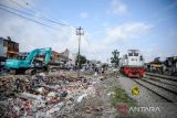 Kereta api melintas di samping proyek pembangunan jalan layang Ciroyom di Andir, Bandung, Jawa Barat, Kamis (5/1/2023). Balai Teknik Perkeretaapian Kelas I Wilayah Jawa Barat bersama Pemerintah Kota Bandung membangun jalan layang serta jembatan penyeberangan orang di Ciroyom guna mengatasi lonjakan kendaraan saat Kereta Cepat Jakarta Bandung beroperasi serta mengurangi kemacetan di kawasan tersebut. ANTARA FOTO/Raisan Al Farisi/agr