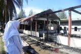 Sejumlah siswa mengamati asrama mereka  yang terbakar di komplek Sekolah Menengah Atas Negeri  (SMAN) Modal Bangsa, di Desa Cot Geundreut, Kecamatan Blang Bintang, kabupaten Aceh Besar, Aceh, Senin (9/1/2023). Tiga unit bangunan asrama siswa dalam komplek SMAN Modal Bangsa itu terbakar dan diduga akibat korsleting listrik menghanguskan sebagian barang perabotan siswa dan tidak ada korban jiwa dalam musibah tersebut. ANTARA FOTO/Ampelsa.