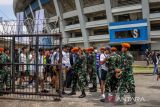 Personel TNI memeriksa penonton yang akan memasuki stadion untuk menyaksikan laga tunda BRI Liga 1 antara Persib Bandung melawan Persija Jakarta di Stadion Gelora Bandung Lautan Api, Bandung, Jawa Barat, Rabu (11/1/2023). Sekitar 4.000 personel gabungan dari TNI dan Polri disiagakan untuk mengamankan laga antara Persib Bandung melawan Persija Jakarta dengan menerapkan sistem pengamanan empat ring. ANTARA FOTO/Raisan Al Farisi/agr