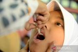 Petugas kesehatan memberikan vaksin polio tetes (Oral Poliomyelitis Vaccine) kepada murid sekolah Madrasah Ibtidaiyah Negeri (MIN) 1 Banda Aceh, di Desa Ateuk Pahlawan, Kecamatan Baiturrahman, Banda Aceh, Aceh, Kamis (12/1/2023). Pemerintah provinsi Aceh mencatat hingga awal Januari 2023, pelaksanaan imunisasi polio di daerah itu sudah mencapai 89 persen dari yang target sebanyak 1,2 juta anak. ANTARA FOTO/Ampelsa.