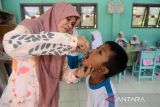 Petugas kesehatan memberikan vaksin polio tetes (Oral Poliomyelitis Vaccine) kepada murid sekolah Madrasah Ibtidaiyah Negeri (MIN) 1 Banda Aceh, di Desa Ateuk Pahlawan, Kecamatan Baiturrahman, Banda Aceh, Aceh, Kamis (12/1/2023). Pemerintah provinsi Aceh mencatat hingga awal Januari 2023, pelaksanaan imunisasi polio di daerah itu sudah mencapai 89 persen dari yang target sebanyak 1,2 juta anak. ANTARA FOTO/Ampelsa.
