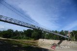 Warga melintasi jembatan gantung saat peresmian di Desa Siron,Kecamatan Kuta Cot Glee, kabupaten Aceh Besar, Aceh, Rabu (11/1/2023).  Kementerian Pekerjaan Umum dan Perumahan Raykat (PUPR) pada tahun 2022 menyelesaikan pembangunan empat jembatan gantung sepanjang 384 meter di provinsi Aceh dengan anggaran sebesar Rp 12,8 miliar untuk mempermudah akses warga pedesaan dan anak sekolah serta meningkatkan perekonomian masyarakat. ANTARA FOTO/Ampelsa.