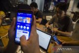 Warga mengisi pulsa melalui aplikasi myXL pada gawai di salah satu kafe di Bandung, Jawa Barat, Kamis (12/1/2023). Jaringan 4G XL Axiata telah melayani lebih dari 57 juta pelanggan dengan jangkauan layanan di lebih dari 61 ribu desa/kelurahan, 5.700 kecamatan, dan 469 kabupaten di 34 provinsi Indonesia dengan dukungan dari lebih dari 90 ribu BTS 4G. ANTARA FOTO/Novrian Arbi/agr