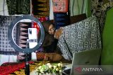 Pelaku UMKM melakukan tayangan siaran langsung melalui media sosial untuk mempromosikan produk batik miliknya di kelurahan Paoman, Indramayu, Jawa Barat, Kamis (12/1/2023). XL Axiata berkomitmen mendukung Pemerintah dalam percepatan digitalisasi wirausaha yang inovatif bagi UMKM menuju pertumbuhan ekonomi nasional serta mendorong pemberdayaan UMKM perempuan dengan pemanfaatan internet guna meningkatkan taraf kehidupan. ANTARA FOTO/Dedhez Anggara/agr