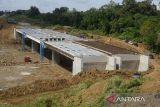 Pekerja menyelesaikan pembangunan jembatan dengan terowongan untuk perlintasan gajah liar di ruas jalan tol seksi-I Padang Tidji-Seulimum, Tol Sigli-Banda Aceh, Kabupaten Aceh Besar, Aceh, Selasa (17/1/2023). PT Hutama Karya (Persero) membangun tiga bagian perlintasan satwa liar di ruas jalan tol Sigli-Banda Aceh dengan kontruksi jembatan untuk gajah, perlintasan menggunakan produk beton tulang pracetak untuk reptil dan perlintasan dengan kontruksi jembatan kanopi jaring kabel untuk primata. ANTARA FOTO/Ampelsa.