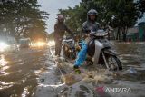 Pengendara sepeda motor mendorong kendaraannya yang mogok saat menerjang banjir di Jalan Soekarno-Hatta, Gedebage, Bandung, Jawa Barat, Rabu (18/1/2023). Meskipun terdapat beberapa kolam retensi di sekitar Gedebage, banjir di kawasan tersebut masih kerap terjadi ketika hujan lebat mengguyur Kota Bandung. ANTARA FOTO/Raisan Al Farisi/agr
