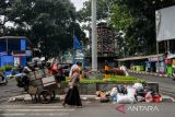 Warga melintas di pinggir tumpukan sampah di Jalan Burangrang, Bandung, Jawa Barat, Kamis (19/1/2023). Dinas Lingkungan Hidup Kota Bandung mencatat, setiap harinya Kota Bandung menghasilkan 1.200 ton sampah dan hanya bisa diangkut 900 hingga 1.000 ton per hari karena adanya permasalahan pengangkutan ke TPA Sarimukti dalam seminggu terakhir. ANTARA FOTO/Raisan Al Farisi/agr