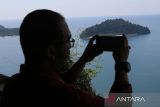 Pengunjung memotret dengan gawai panorama di puncak wisata gunung Geurute, Aceh Jaya, Aceh, Jumat (20/1/2023). ANTARA Aceh/Syifa Yulinnas.