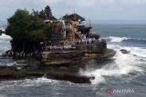 Umat Hindu mengantre memasuki pura saat akan melaksanakan persembahyangan pada Hari Suci Siwaratri di Pura Tanah Lot, Tabanan, Bali, Jumat (20/1/2023). Persembahyangan di Pura yang berlokasi di tengah laut tersebut berjalan lancar dengan memperhitungkan pasang surutnya air laut. ANTARA FOTO/Nyoman Hendra Wibowo/wsj.