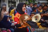 Seorang anggota kelompok barongsai mengenakan hijab saat memainkan perkusi saat atraksi barongsai saat perayaan Imlek di depan Vihara Buddha Sakyamuni Banda Aceh, Provinsi NAD, Minggu (22/1/2023). Kelompok barongsai juga ada yang muslim karena barongsai sudah menjadi cabang olahraga yang diperlombakan. Antara Aceh/FB Anggoro.