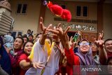 Sejumlah warga berusaha menangkap boneka yang dilemparkan barongsai saat perayaan Imlek di depan Vihara Buddha Sakyamuni Banda Aceh, Provinsi NAD, Minggu (22/1/2023). Antara Aceh/FB Anggoro.