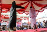 PELAKSANAAN HUKUMAN CAMBUK DI ACEH BARAT. Terpidana pelanggar peraturan daerah (qanun) Syariat Islam (tengah) menjalani proses eksekusi hukuman cambuk di halaman Lembaga Pemasyarakatan kelas II B Meulaboh, Aceh Barat, Aceh, Selasa (24/1/2023). Mahkamah Syariah Kabupaten Aceh Barat menjatuhkan hukuman 100 kali cambuk terhadap dua terpidana yang terbukti melanggar peraturan daerah (qanun) pasal 33 ayat (1) nomor 6 tahun 2014 tentang hukum jinayat sebagai wujud penegakkan syariat islam di Provinsi Aceh. ANTARA FOTO/Syifa Yulinnas